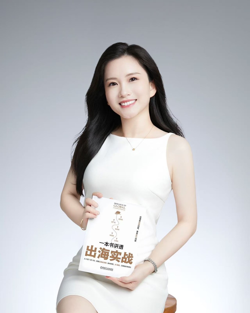 Annie Chan holding her book on cross-border growth